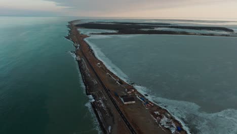 aerial view of road in notsuke peninsula during winter in hokkaido, japan. - pullback shot