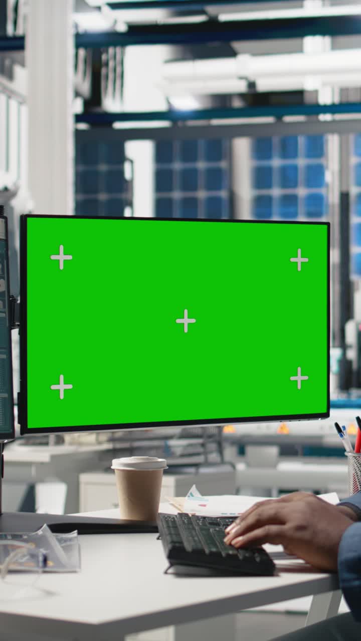Vertical Video Male tech specialist reviewing assembly line next to mockup on pc