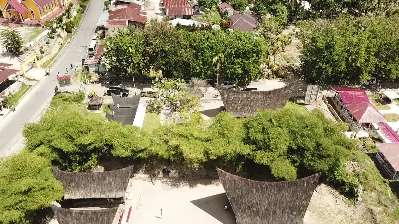 vista de drones de casas batak tradicionales con techo de paja en la isla de samosir, lago toba, sumatra, indonesia