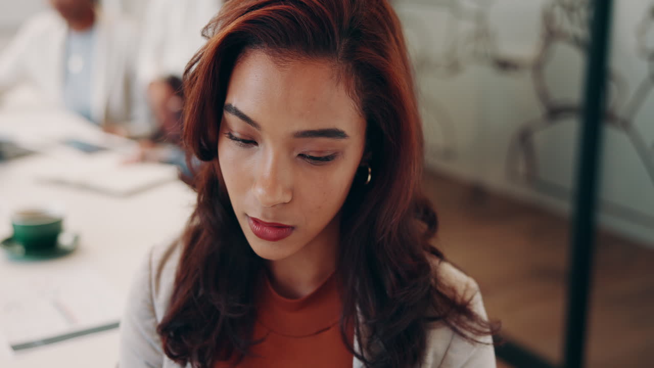 젊은 사업가 여성이 사무실에서 회의 중에 생각하고 있습니다.