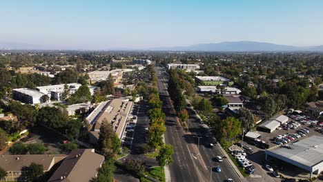 vista aérea de la ciudad de sunnyvale con árboles, carretera principal, casas y montañas al fondo por la tarde