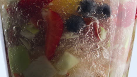 frutas giratorias mezclador de bayas en súper cámara lenta de cerca. cocinar batido.