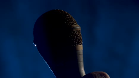 microphone rises into a shot on a smokey background