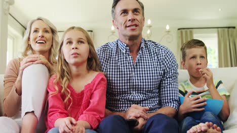 happy family watching television together in living room