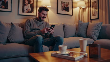 man relaxing on couch with phone