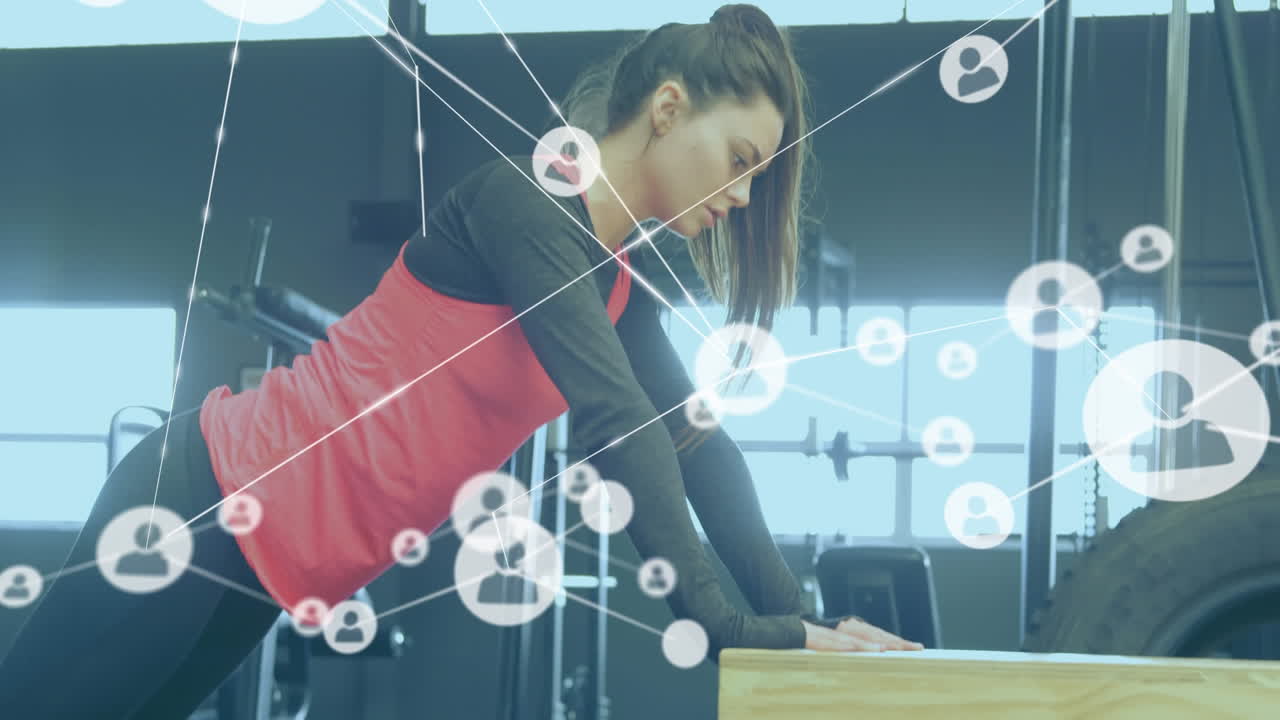 red de iconos de conexión contra una mujer haciendo ejercicios de flexión en el gimnasio