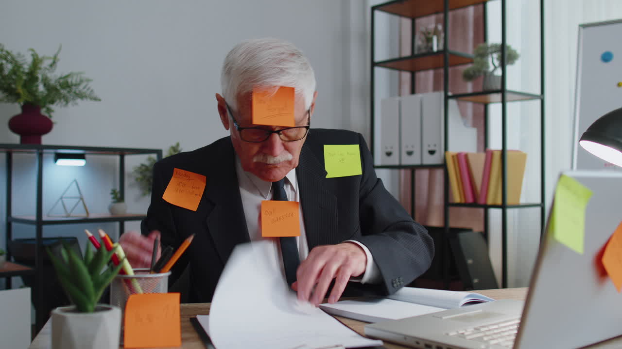 Tired exhausted senior business man office manager with laptop sticky notes sticks with many tasks