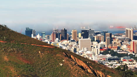 Coastal-city-hiding-behind-grass-slope.-Modern-urban-borough-and-surrounding-landscape.-Cape-Town,-South-Africa