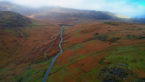 rural road crossing pen-y-pass mountain in snowdonia, uk