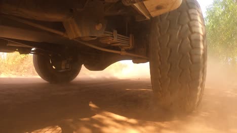 the rear wheels powertrain system of the 4 wheels off road drive light truck driving on dirt and dust ground