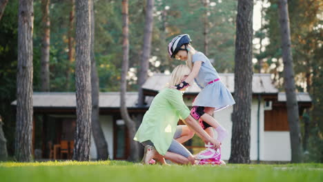 Happy-Childhood-A-Young-Mother-Helps-To-Put-Roller-Skates-On-Her-Daughter-In-The-Backyard-Of-Their-H