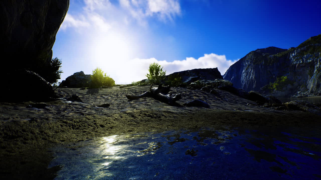 Sunrise over rocky landscape with reflections in calm water