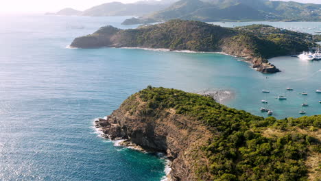 Sonnige-Luftaufnahme-Des-Englischen-Hafens-In-Antigua,-Karibik-Mit-Blick-Auf-Yachten,-Segelboote,-Marina,-Bucht-Und-Klippen