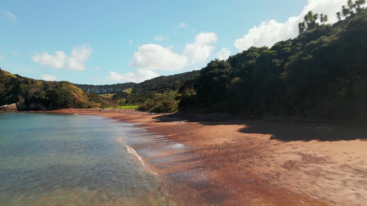 orilla de arena marrón de la bahía de rangihoua en un día soleado en la península de purerua en la bahía de islas, norte, nueva zelanda