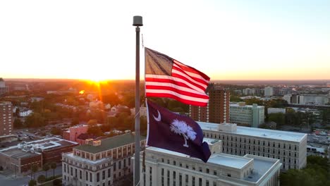 american and south carolina flags waving atop capitol building in downtown columbia, sc