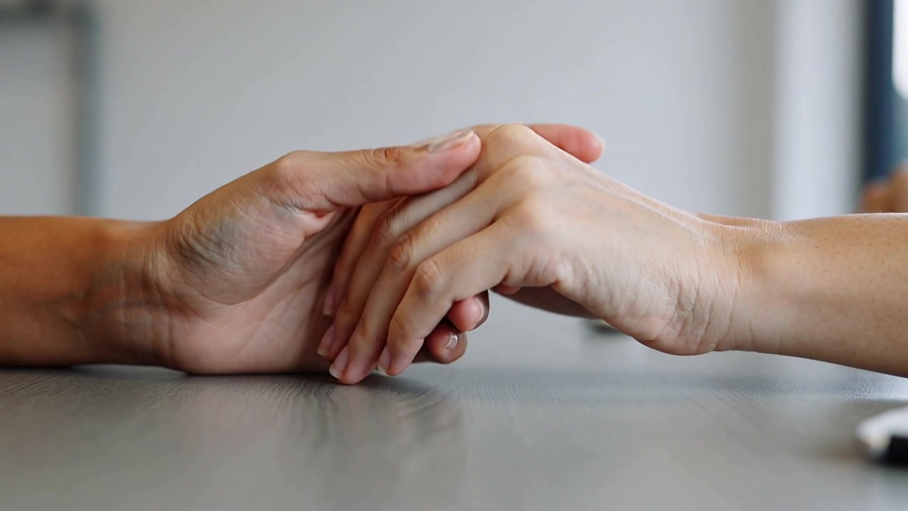 Putting palm down one hand causing other reaching covering holding at table soothing device right