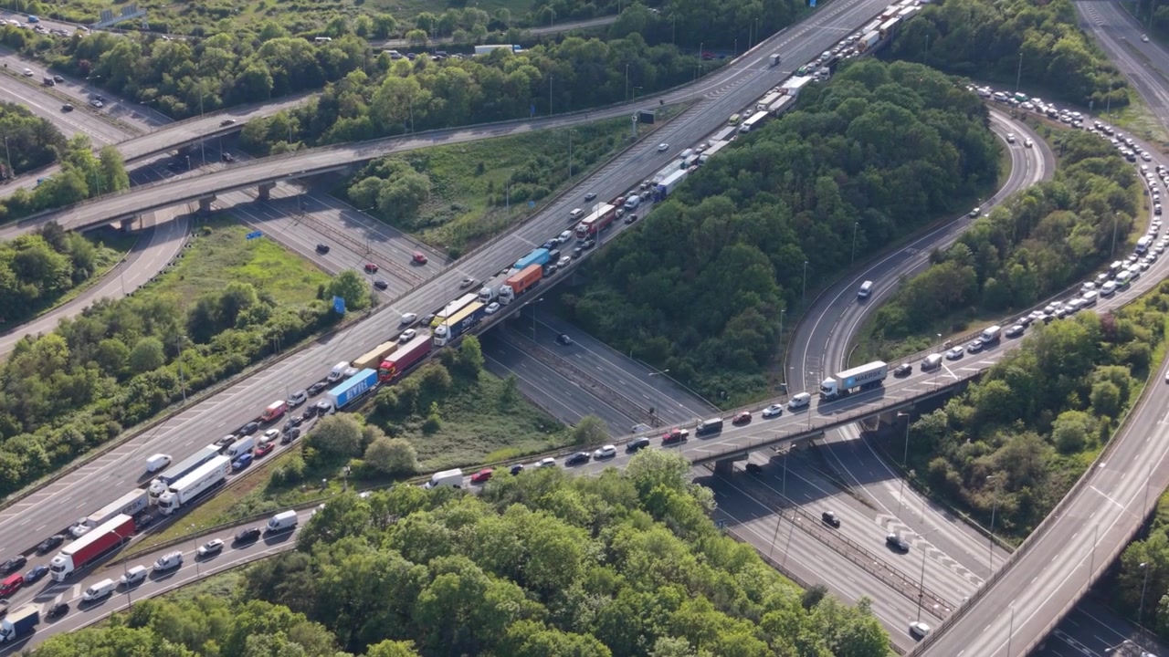 Luftperspektive zeigt einen schweren Stau auf einer mehrspurigen Autobahn und einem komplexen Verkehrsknotenpunkt.
