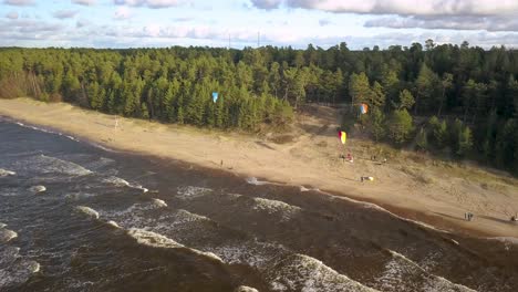 Paragliders-hovering-in-the-air-on-the-beach,-beautiful-sunny-day-in-Latvia
