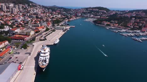 amazing reveal shot from left to right in dubrovnik, croatia with mountains, boats and crystal clear water in 4k panning down