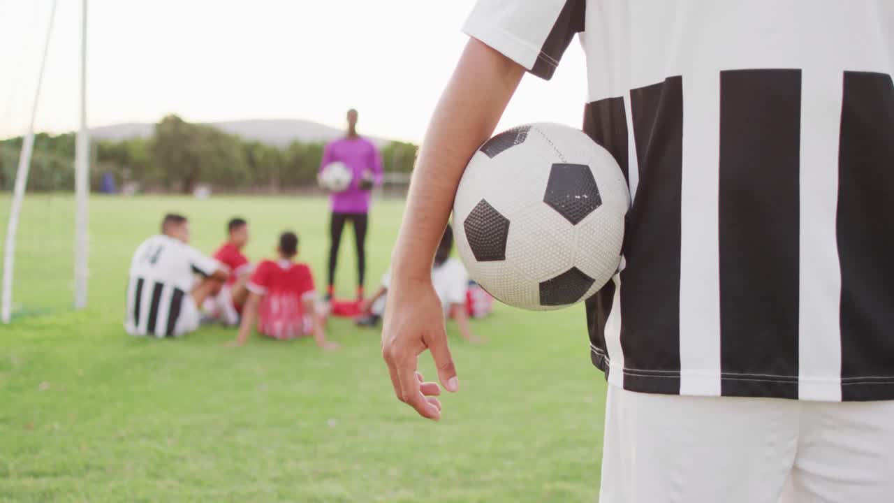공 을 들고 필드 에 있는 두 인종 의 축구 선수 의 영상