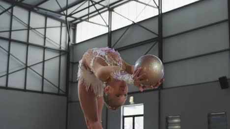 teenage female gymnast performing at sports hall