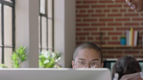 joven de raza mixta usando computadora útil líder de equipo afroamericano compartiendo ideas apuntando a la pantalla entrenando colega discutiendo solución de proyecto en oficina diversa