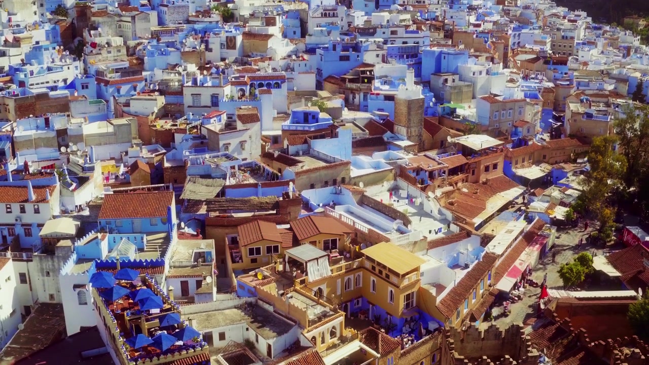Drone, Chefchaouen medinasının üzerine yükselerek mavi çatıları ve kıvrımlı sokakları ortaya çıkaran yukarıdan aşağıya bir görünüm sunuyor.