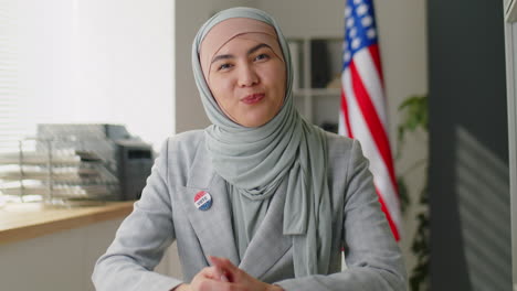 muslim woman in hijab inviting people to vote