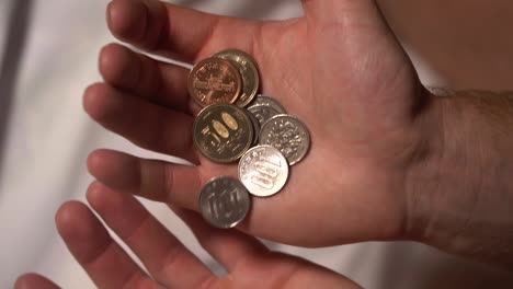 un primer plano en cámara lenta de monedas y dinero de japón y asia fluyendo de mano en mano