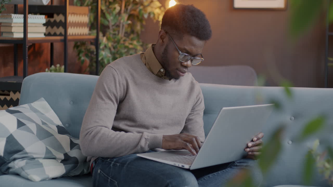 hombre trabajando en una computadora portátil en casa