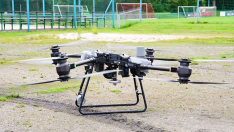 Large-delivery-drone-landing-procedure-on-outdoor-gravel-surface,-Czechia