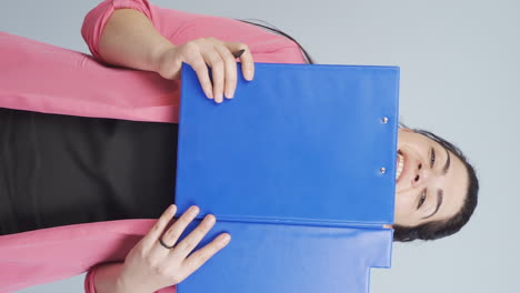 Vertical-video-of-Business-woman-looking-from-behind-files.