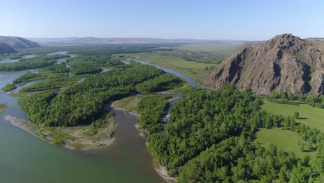 aerial view of a river winding through a valley with mountains in the background