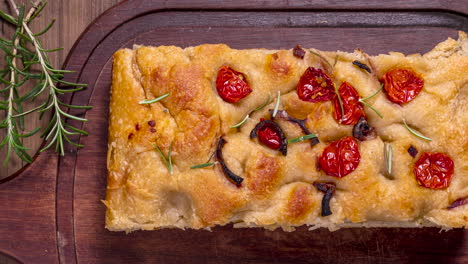 Traditional-Italian-Focaccia-with-pepperoni,-cherry-tomatoes,-black-olives,-rosemary-ando-onion---homemade-flat-bread-focaccia