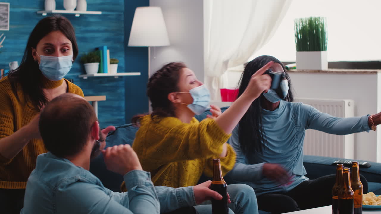 Friends with masks holding controllers playing video game