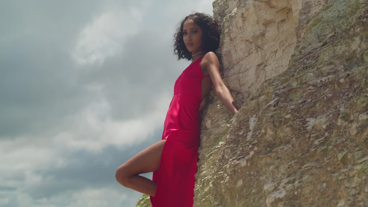 Una ragazza che indossa un sorprendente vestito rosso si gode la vista da San Fernando Hill, dove la città e la costa si incontrano.