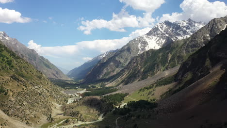 aerial shot of the mountains valley and clouds at naltar valley in pakistan, revealing drone shot