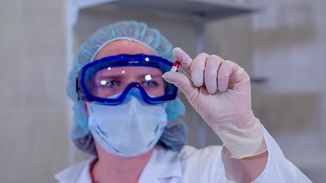 Doctor holding a pill in a lab
