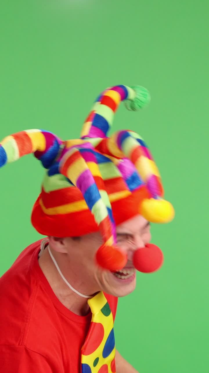 Clown with jester hat and red nose laughing