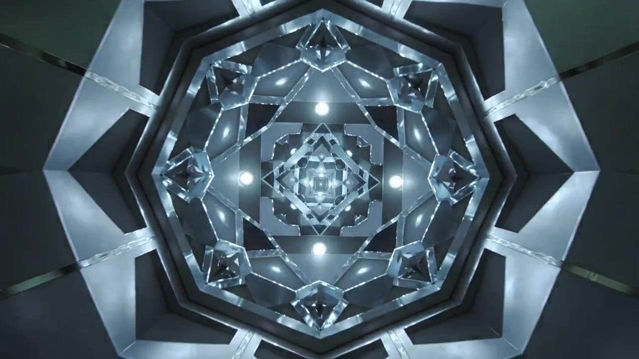 La telecamera si allontana per mostrare pannelli a specchio disposti ad anello all'interno di una camera, con nervature ottagonali e LED.