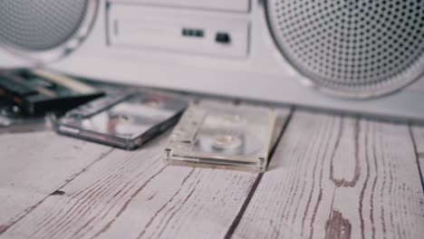 female hands throwing a lots old audio cassettes on table. 4k. close up