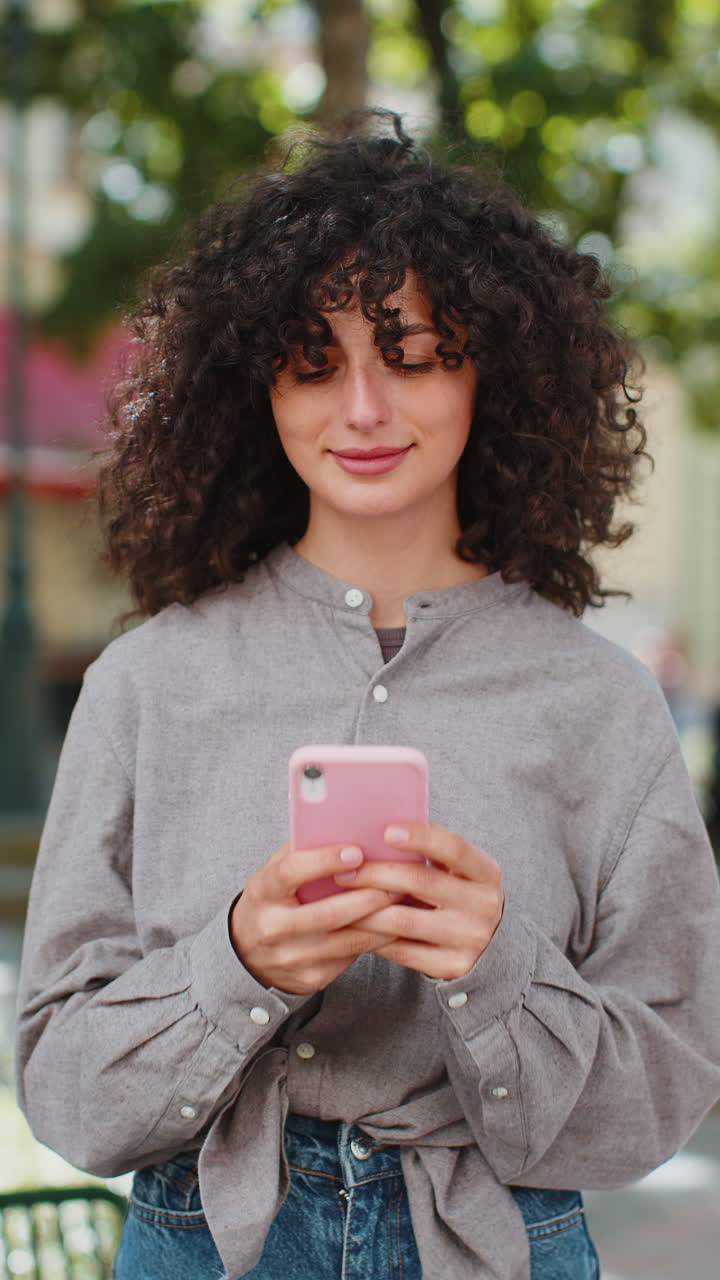 mujer joven usa teléfono inteligente escribiendo mensajes de texto navegando por internet terminando el trabajo mirando a la cámara