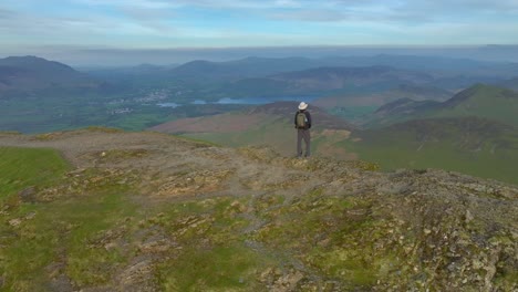 Mountain-walker-on-rounded-fell-summit-at-golden-hour