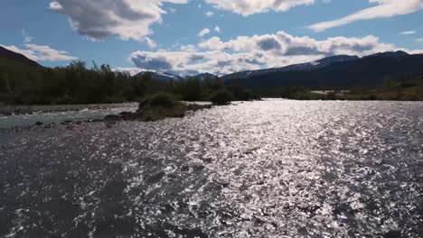 aerial view of a flowing river shimmering under the sunlight in besseggen, innlandet, norway with mountain landscape