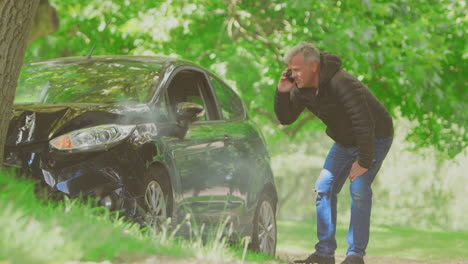 Mature-Man-Gets-Out-Of-Smoking-Car-And-Inspecting-Accident-Damage-Before-Calling-Emergency-Services