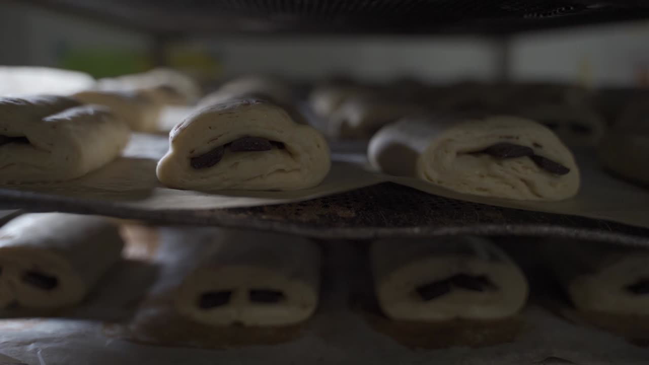 many chocolate croissant unbaked on a trolley in a bakery