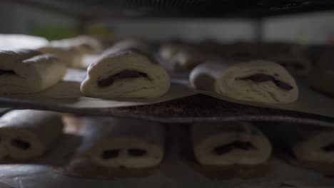 many chocolate croissant unbaked on a trolley in a bakery