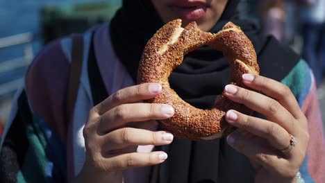 mujer sosteniendo un simit, un pan tradicional turco