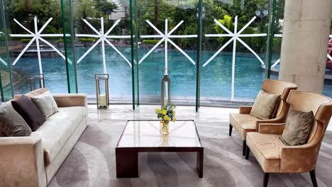 living room of luxurious home with taped windows overlooking raining pool area