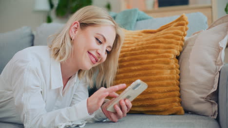 young woman shops online on sofa